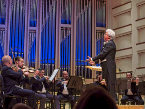 Conductor with orchestra onstage