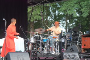 singer in red dress looking at drummer